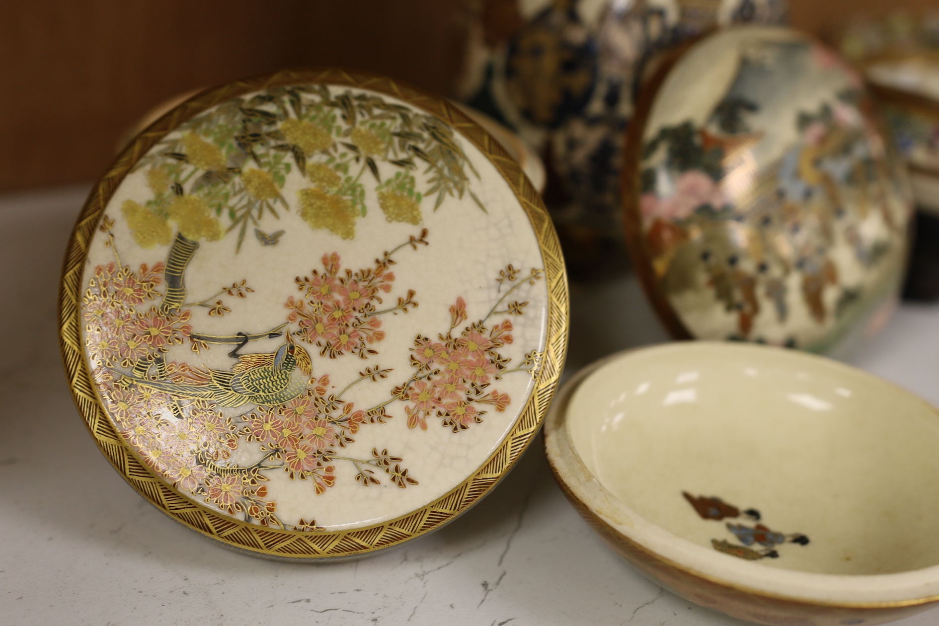 A late 19th century Japanese Satsuma ‘hundred antiques’ gosu blue pot pourri vase and three later items of Satsuma, including a bowl and cover a bowl on stand, a box and cover, tallest 18.5cm high. Condition - vase cover